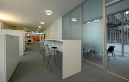 Großraumoffice / Chat-Tresen und im Hintergrund Mitarbeiter-Meetingraum